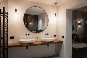 two sinks in a bathroom with a mirror at Boutique Hotel Huys Oud Teylingen in Warmond