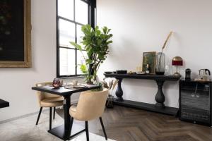 a dining room with a black table and chairs at Boutique Hotel Huys Oud Teylingen in Warmond