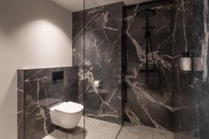 a bathroom with a toilet and a glass shower at Boutique Hotel Huys Oud Teylingen in Warmond +26 photos