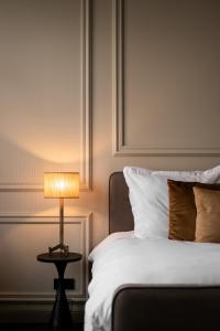 a bedroom with a bed with a lamp on a table at Boutique Hotel Huys Oud Teylingen in Warmond