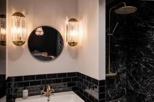 a bathroom with a sink and a mirror at Boutique Hotel Huys Oud Teylingen in Warmond