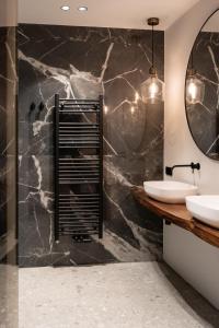 a bathroom with two sinks and a mirror at Boutique B&B Huys Oud Teylingen in Warmond