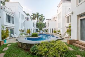 a courtyard with a swimming pool in a building at Snowdrop- Exquisite 3BHK Villa with Pool- Candolim By StayMonkey in Calangute