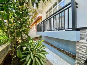 a house with a blue balcony and plants at Mountain White Villa by Sunrise in Kandy