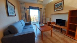 sala de estar con sofá y TV en Apartamentos Baños de Ledesma, en Salamanca