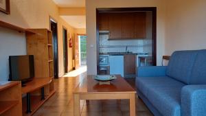 - un salon avec un canapé bleu et une table dans l'établissement Apartamentos Baños de Ledesma, à Salamanque