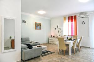a living room with a table and a dining room at Apartman LUI in Rijeka