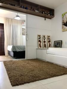 a bedroom with a bed and a brown rug at APARTAMENTO NA PRAIA no CONDOMÍNIO JUBIABÁ em OLIVENÇA - ILHÉUS in Ilhéus