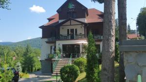 a large house with a balcony and stairs to it at Vila Laura 1 in Sovata
