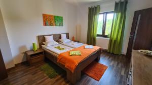 a bedroom with a large bed with an orange blanket at Vila Laura 1 in Sovata