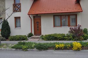 une maison blanche avec un toit orange dans l'établissement Betérő Apartman Veszprém, à Veszprém