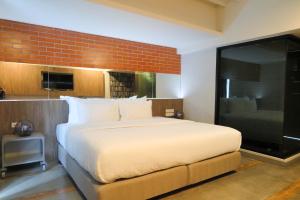 a bedroom with a large bed and a brick wall at V20 Boutique Jacuzzi Hotel in Bangkok