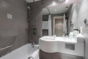 a bathroom with a tub, sink and mirror at Holiday Inn London - Regent's Park, an IHG Hotel in London