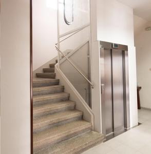 un conjunto de escaleras con ascensor metálico en Hostal San Cristobal en Pontedeume, en Puentedeume