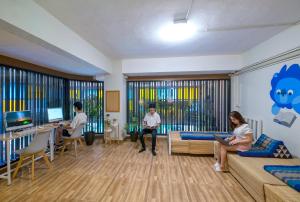 a group of people sitting in a living room at BED Friends Poshtel in Chiang Rai