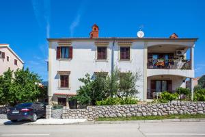 a building with a car parked in front of it at Apartment Mužić in Cres +3 photos