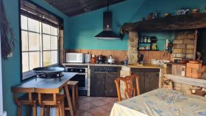 cocina con paredes azules y mesa con sillas en Apartamento A Guarda, en A Guarda