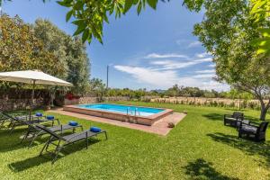 una piscina en un patio con sillas y sombrilla en Villa Payeras, en Puerto Pollensa