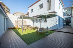 a patio with a table and chairs and an umbrella at MyStay Matosinhos Centro in Matosinhos