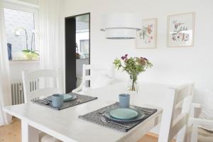 a white dining room table and chairs with a vase of flowers at Ferienapartment Landwohnung Theresa in Winterberg