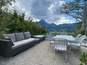 un patio con sofá, mesa y sillas en Ferienhaus Relax, en Schwarzsee