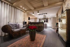 - un salon avec un canapé et un vase de fleurs dans l'établissement Chalet Migui Luxury Living & Spa *****, Crans Montana, à Crans-Montana