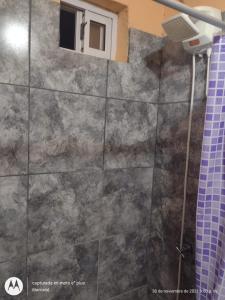 a bathroom with a shower curtain and a window at jazmin apart iguazu in Puerto Iguazú