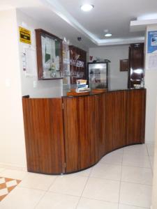 a wooden counter in a store with a cash register at Hostal Fevilamir in Ibarra