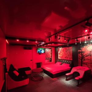 - une chambre rouge avec un lit et des chaises dans l'établissement "DREAM ROOM" Тематические апартаменты Харьков! Цоколь!, à Kharkov