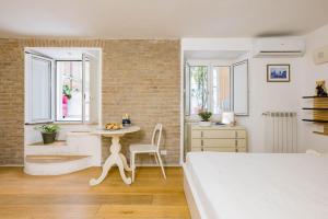 a bedroom with a white bed and a brick wall at Alveare Bed & Breakfast in Rome