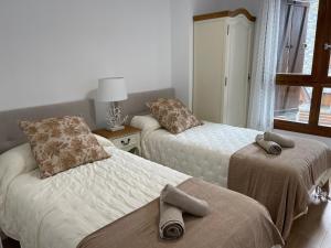 ein Schlafzimmer mit 2 Betten und Handtüchern darauf in der Unterkunft Blanchard Benas 2 in Benasque