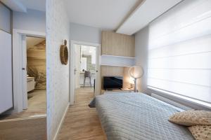 a bedroom with a bed and a window and a desk at Victus Apartamenty, Apartamenty Delux in Sopot