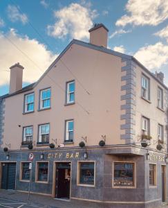 un gran edificio blanco con un letrero que lee el bar de la ciudad en 3 BEDROOM LUXURY APARTMENT Across the street from THE CASHEL PALACE HOTEL, en Cashel