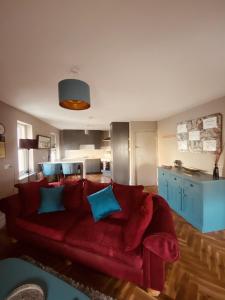 sala de estar con sofá rojo y almohadas azules en 3 BEDROOM LUXURY APARTMENT Across the street from THE CASHEL PALACE HOTEL, en Cashel