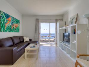 a living room with a couch and a tv at FIRST LINE MOGAN BEACH - Parking free in Mogán