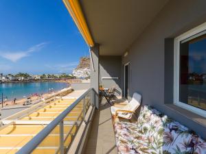a balcony with chairs and a view of the beach at FIRST LINE MOGAN BEACH - Parking free in Mogán