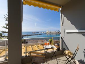 een balkon met een tafel en stoelen en uitzicht op de oceaan bij FIRST LINE MOGAN BEACH - Parking free in Mogán