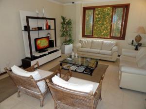 a living room with a couch and a table at Village du Soleil in Cabo Frio