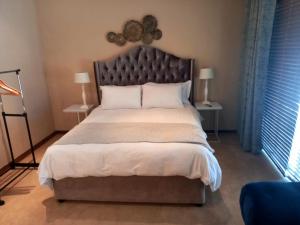 a bedroom with a large bed with a large headboard at The Hills Guest House in Newcastle