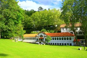 a large white building with a red roof on a green field at Hotel Caldelas in Caldelas