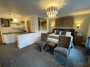 um quarto com uma cama, uma secretária e uma cadeira em The Townhouse Boutique Hotel em Barrow in Furness