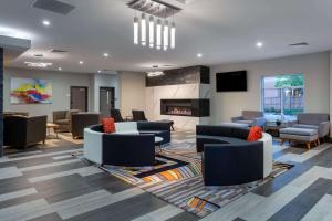 a lobby with couches and chairs and a fireplace at Baymont by Wyndham Madison in Madison