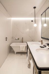 a white bathroom with a tub and a sink at Luxury Apartments Palazzo Nani in Venice