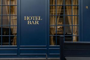 ein Schild der Hotelbar an der Seite eines Gebäudes in der Unterkunft Maison Barbès in Paris