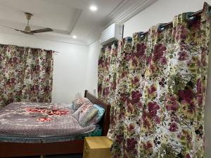 1 dormitorio con 1 cama y cortinas con flores en Brand New 3-Bed House in Oyibi Accra Ghana, en Oyibi