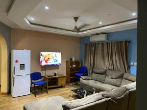 sala de estar con sofá y nevera blanca en Brand New 3-Bed House in Oyibi Accra Ghana, en Oyibi