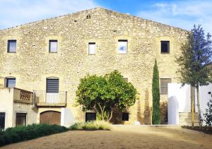 a large stone building with a tree in front of it at Bonaire Suites in Sant Mori