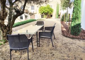 une table et des chaises assises sous un arbre dans l'établissement Bonaire Suites, à Sant Mori