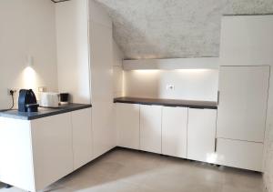 a kitchen with white cabinets and a ceiling at Bonaire Suites in Sant Mori