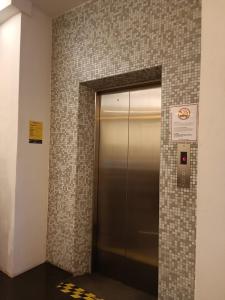 a elevator in a building with a tile wall at SO Hotel in George Town